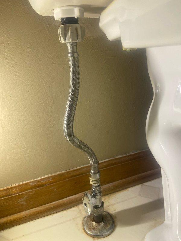 Replaced corroded toilet shut-off valve in main floor bathroom with new quarter-turn valve and installed new braided supply line. Tested water flow and verified proper operation with no leaks at connections.