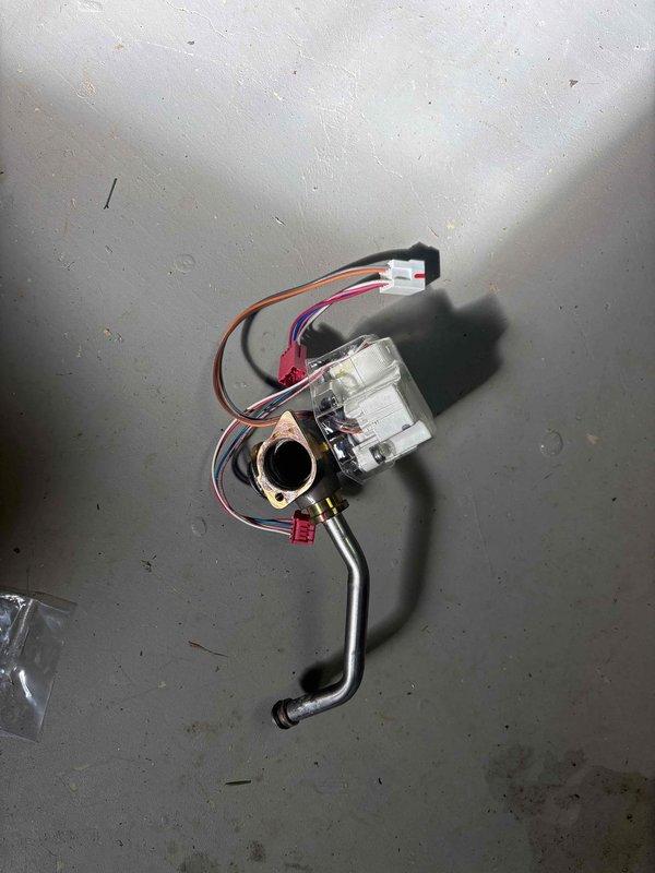 Replaced defective hot water servo valve assembly and installed new relief pipe assembly on tankless water heater. System diagnostic confirmed proper operation with normal temperature readings on digital display panel. All connections secure and system functioning as designed.