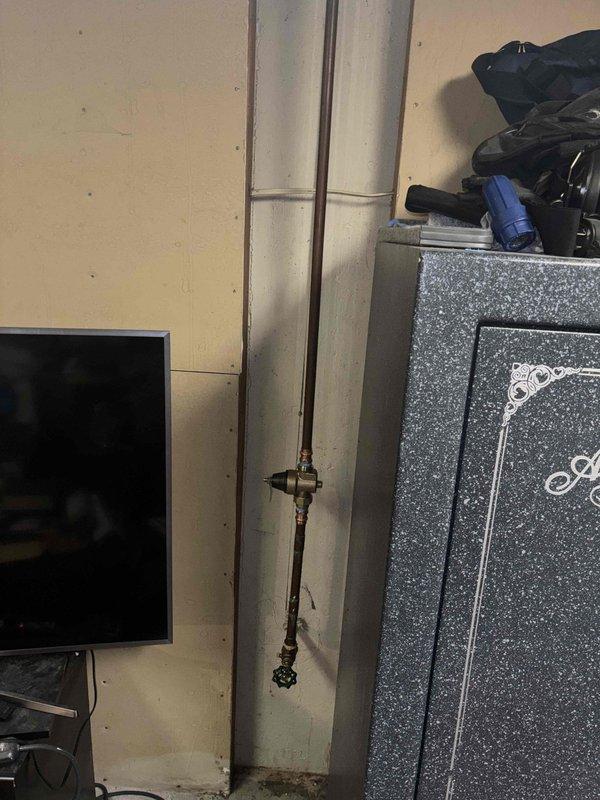 Responded to recall job #1292865 regarding water heater leak. Inspected copper pipe installation and connections in basement utility area. Found and repaired leaking joint at 90-degree elbow connection where previous sealant had failed, ensuring proper water flow and preventing further water damage.