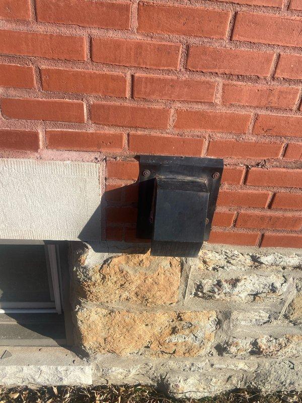 Conducted assessment of 20-year-old tankless water heater in basement for potential replacement. Inspection revealed system is currently operational but approaching end of service life. Examined surrounding infrastructure including ventilation ducts and water supply connections mounted on masonry wall. Documented existing installation conditions to prepare appropriate replacement options.