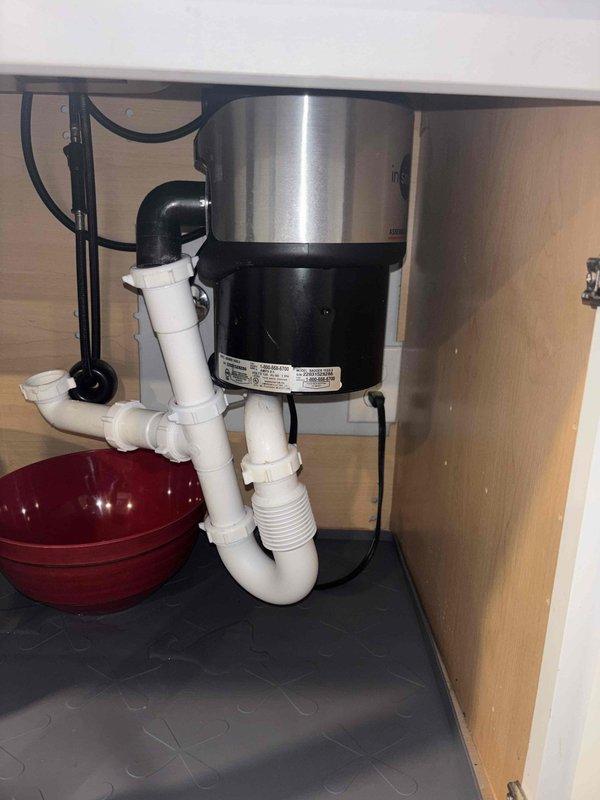 Responded to service call for leaking pipes under kitchen sink. Upon inspection, identified loose connection at P-trap assembly connected to garbage disposal unit. Disassembled affected PVC components, cleaned pipe threads, applied new plumber's tape, and reassembled with proper torque. Tested repair by running water through system and confirmed leak was successfully resolved.