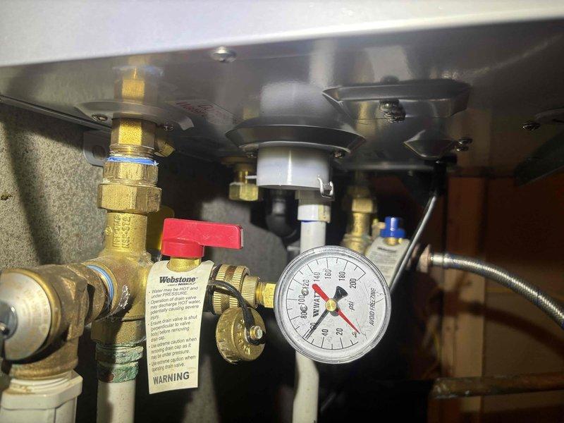 Performed scheduled tankless water heater flush service between 8-12. Inspected electrical connections and wiring configuration within the unit, ensuring all terminals were secure. Checked system pressure gauge (reading 100-120 PSI) and verified proper operation of brass valves and fittings. Documented condition with photos for service records.