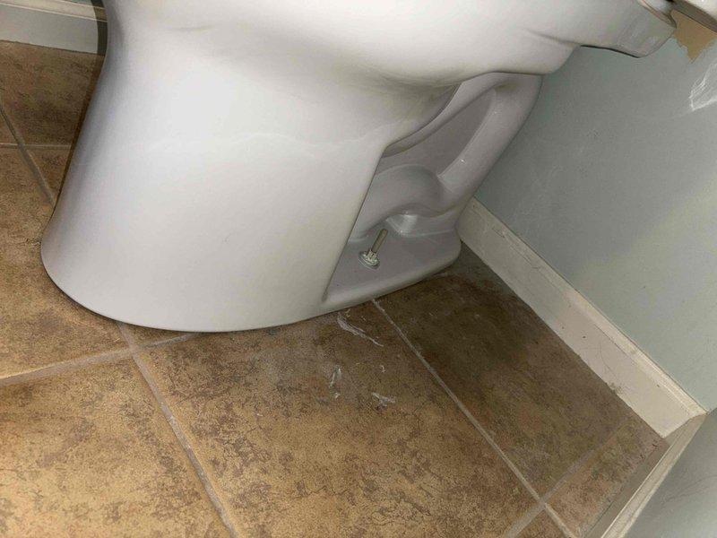 Successfully installed three Toto Drake toilets in the bathroom, securing each fixture properly to the beige tile flooring with mounting bolts. All units were tested for proper operation and sealing, with no leaks detected at the base connections.
