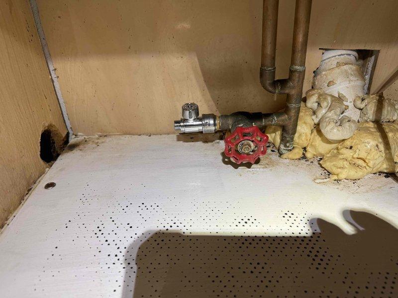 Replaced leaking water shut-off valve for dishwasher. Removed deteriorated foam insulation around copper supply lines and installed new quarter-turn ball valve, securing proper connection to prevent future leaks.