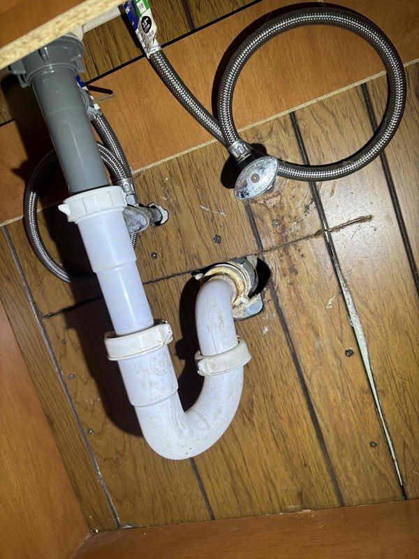 Cleared bathroom sink clog by disassembling the PVC P-trap assembly and removing accumulated debris around the drain. After cleaning, reassembled the plumbing components including the P-trap and braided stainless steel supply lines, and verified proper drainage with no leaks.