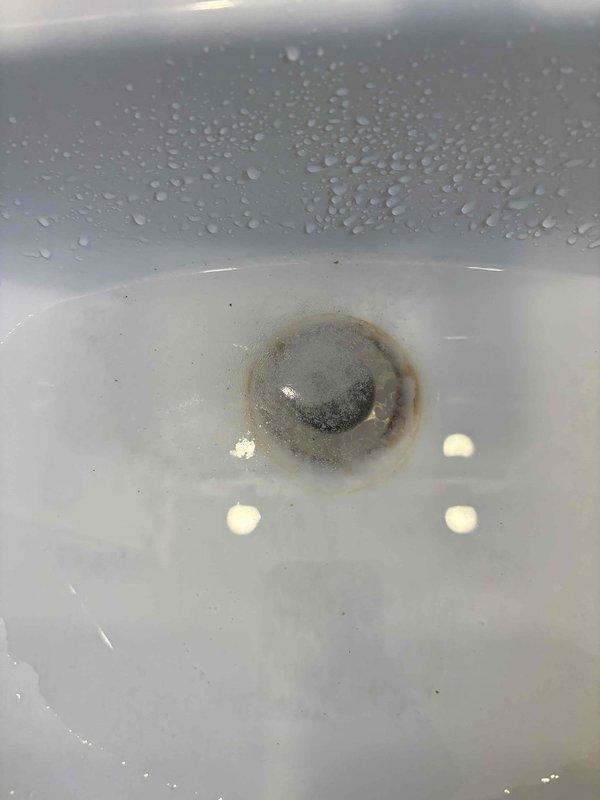 Cleared bathroom sink clog by disassembling the PVC P-trap assembly and removing accumulated debris around the drain. After cleaning, reassembled the plumbing components including the P-trap and braided stainless steel supply lines, and verified proper drainage with no leaks.