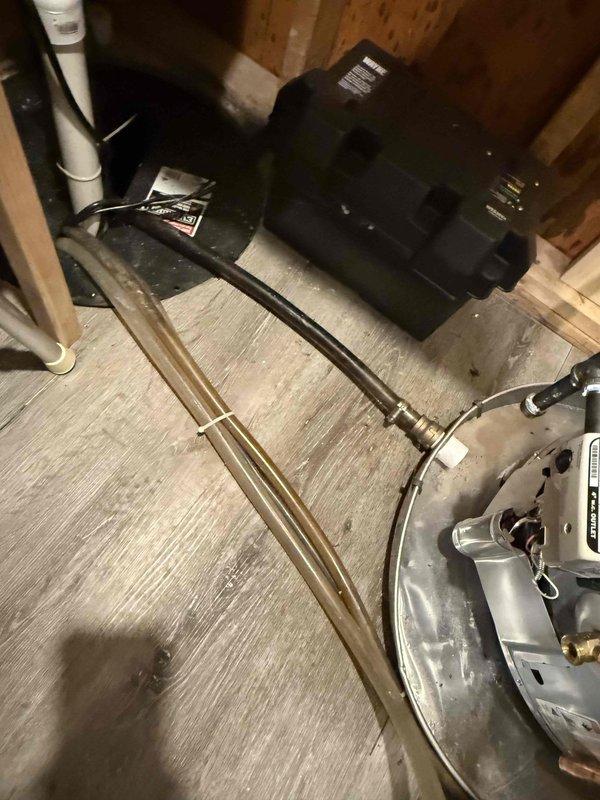 Successfully installed a new 40-gallon Ruud gas water heater with expansion tank in utility room, replacing the previous unit which showed signs of water damage to surrounding surfaces. Installation required two technicians to navigate stairway access constraints, with all connections properly fitted using copper piping and appropriate valves.