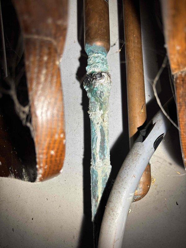 Repaired significant leak at copper pipe connection near main water shutoff valve, evidenced by severe verdigris corrosion and mineral buildup. Removed and replaced failing electric water heater with customer-provided unit, ensuring proper installation of all connections including copper and PEX piping, pressure relief valve, and appropriate valves for isolation.