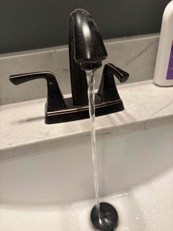 Cleared heavily clogged shower drain with significant debris buildup and descaled bathroom sink aerator to restore proper water pressure. Verified both fixtures now functioning correctly with normal drainage and flow.