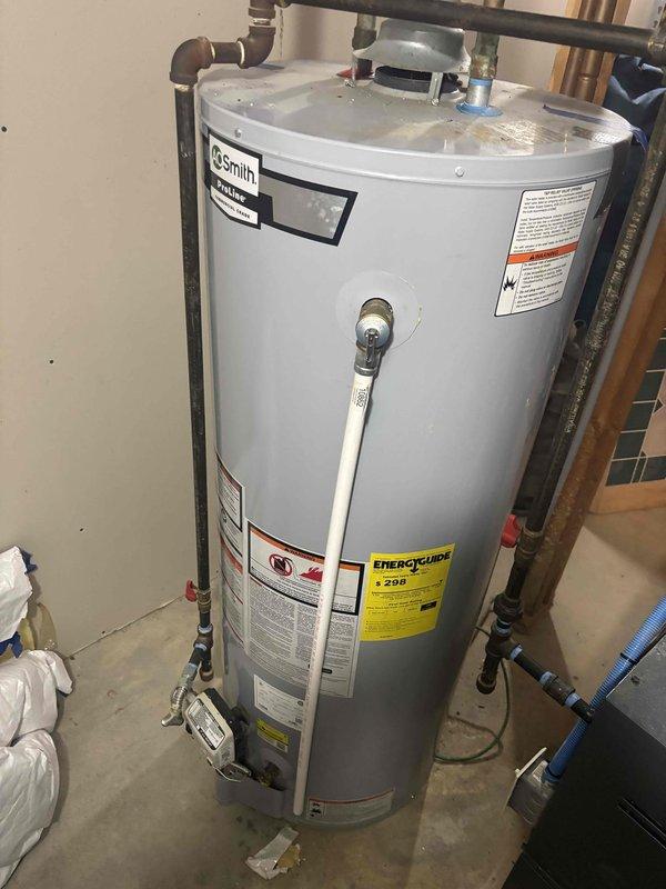 Conducted assessment of customer's 6-year-old tankless water heater located in basement. Upon inspection, identified an A.O. Smith GCG-50 400 model with 50-gallon capacity and 40,000 BTU input (manufactured 01/17/2020). System is currently operational but customer is considering replacement options for their existing unit.