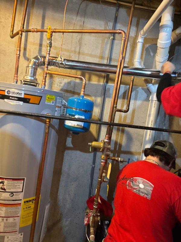 Installed new 50 gallon State ProLine natural gas water heater with associated copper piping and blue expansion tank mounted vertically. Completed all necessary connections including gas line, water supply lines, and proper venting to ensure safe and efficient operation per manufacturer specifications.