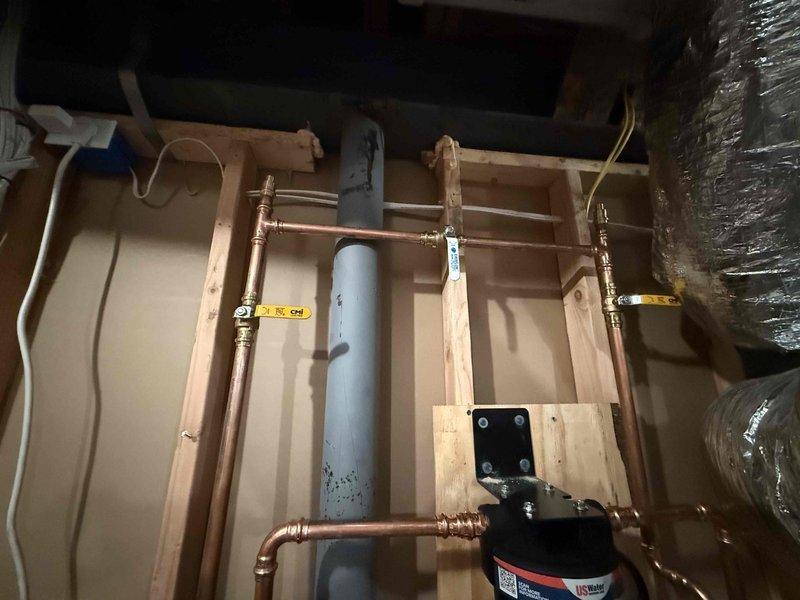 Successfully installed customer-supplied water softener system adjacent to outlet near Wi-Fi equipment. Tapped into main water line after the first hose bib to ensure proper functionality, then ran main feed to softener and connected softened water back into the cold side feed near the water heater. System was properly programmed and initial flush completed to remove shipping debris from the system.