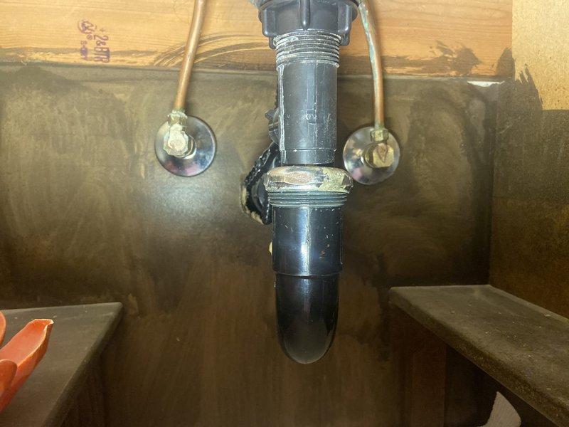 Conducted plumbing assessment and inspection of existing under-sink plumbing showing signs of aging and possible water damage. Evaluated bathroom currently undergoing demolition with exposed wall cavity, visible studs and insulation around bathtub area. Documented customer requirements for multiple plumbing upgrades including installation of shut-off valves, new water/drain lines for laundry room, exterior faucet repair, and shower head relocation for bathroom remodel project.