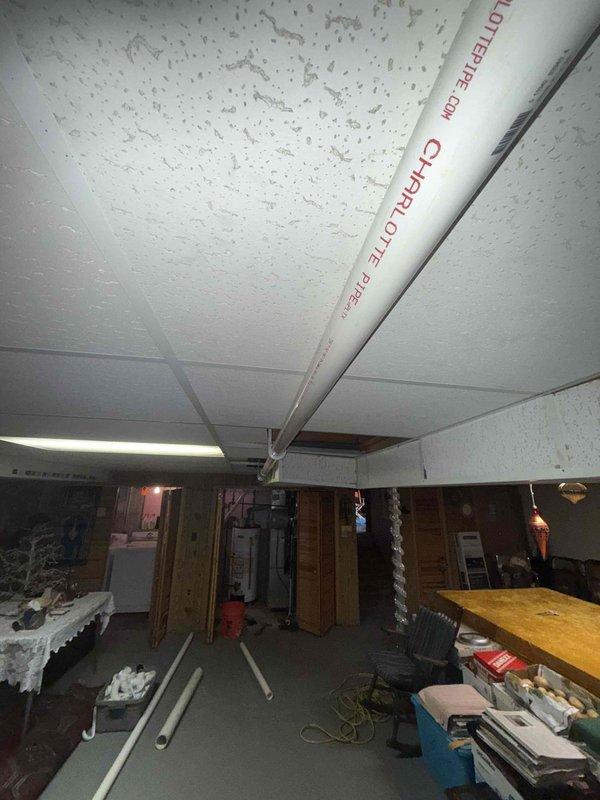Successfully installed new kitchen drain line by cutting kitchen stack after the 45-degree fitting and installing a 90-degree elbow to redirect flow. Ran PVC piping with proper 1/4" per foot fall across ceiling, transitioning through wall to connect to main stack using a 3" x 2" wye fitting. Complete installation provides proper drainage while maintaining code-compliant pitch.