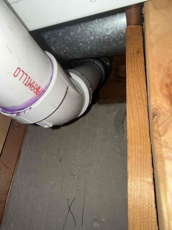 Successfully installed new kitchen drain line by cutting kitchen stack after the 45-degree fitting and installing a 90-degree elbow to redirect flow. Ran PVC piping with proper 1/4" per foot fall across ceiling, transitioning through wall to connect to main stack using a 3" x 2" wye fitting. Complete installation provides proper drainage while maintaining code-compliant pitch.