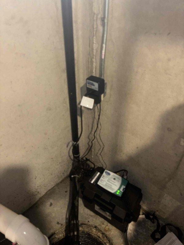 Successfully installed new sump pump in 20-year-old home's basement utility area. Replaced existing unit with upgraded model, ensuring proper electrical connections to control box with indicator light. Verified system functionality with water drainage through PVC piping.