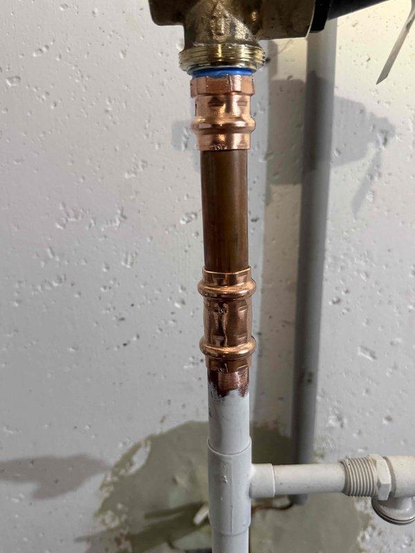 Responded to recall job regarding a leaking pressure valve in basement. Upon inspection, found and replaced the defective brass pressure valve that was leaking at the copper pipe connection. Installed new valve with proper blue gasket seal at the threaded connection point and verified system operation with no leaks present.