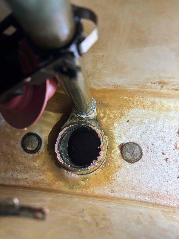 Performed service on tanked water heater, cleaning corroded drain valve and surrounding area to restore proper drainage function. Inspected running toilet in bathroom, identifying and repairing worn internal components to eliminate continuous water flow. Documented significant corrosion around water heater drainage components with photographs for service records.