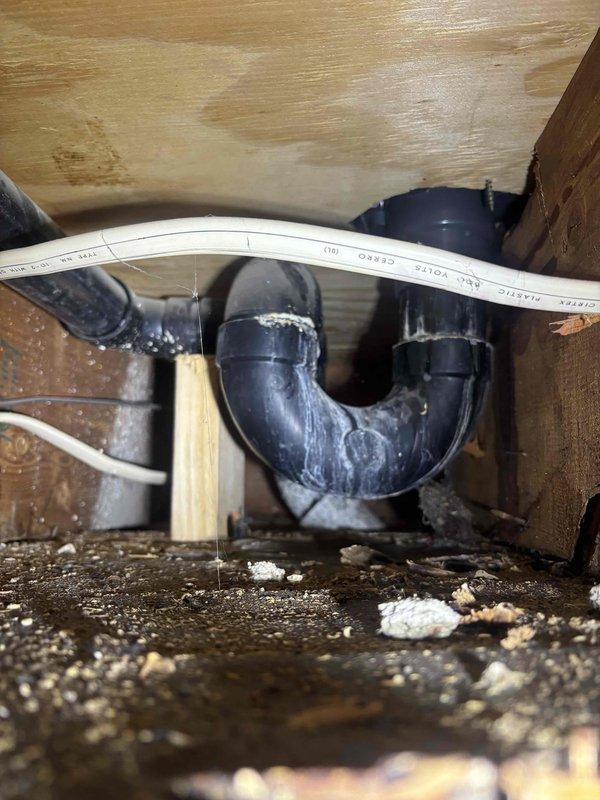 Responded to service call for shower drain leak in primary bathroom. Inspected plumbing system and identified mineral deposit buildup on PVC drain pipes and P-trap configuration. Cleaned affected components, checked all connection points, and verified proper drainage function. Leak successfully repaired with no further issues detected.