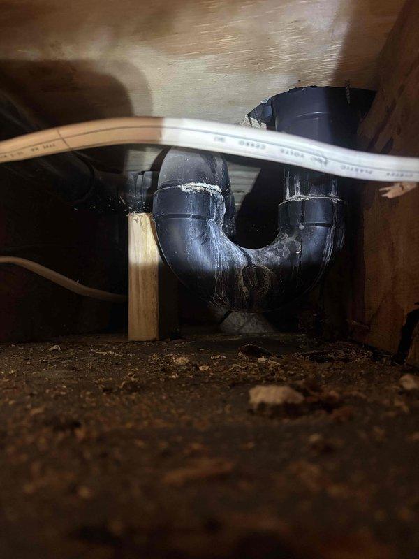 Responded to service call for shower drain leak in primary bathroom. Inspected plumbing system and identified mineral deposit buildup on PVC drain pipes and P-trap configuration. Cleaned affected components, checked all connection points, and verified proper drainage function. Leak successfully repaired with no further issues detected.