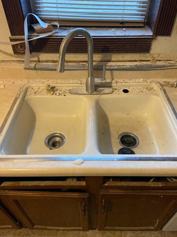 Performed assessment of kitchen sink area in preparation for upcoming demolition work. Disconnected dual-basin sink faucet as requested, ensuring water supply lines were properly secured. Verified all plumbing connections and documented current installation configuration with photos for reference during future renovation work.