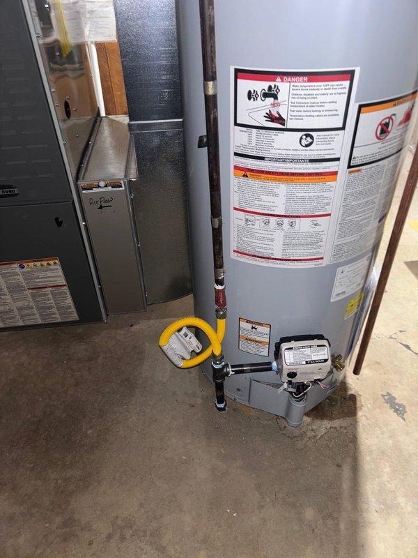 Successfully installed a 40-gallon gas water heater with thermal expansion tank in basement utility area. Connected unit to existing plumbing and gas lines using appropriate fittings and safety mechanisms. Added 1/4 turn stop for humidifier and verified all connections are secure with proper labeling in place.