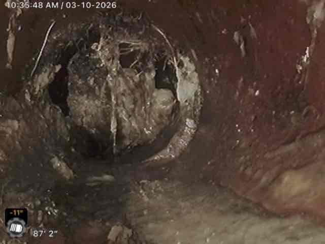 Performed camera inspection of main line in response to a second opinion request regarding a potential line break near city connection. Inspection revealed significant buildup of debris and mineral deposits on pipe walls with partial blockage visible. Inspection footage documented deteriorating pipe condition with mottled surfaces and moisture accumulation, confirming issues that require attention before connecting to municipal system.