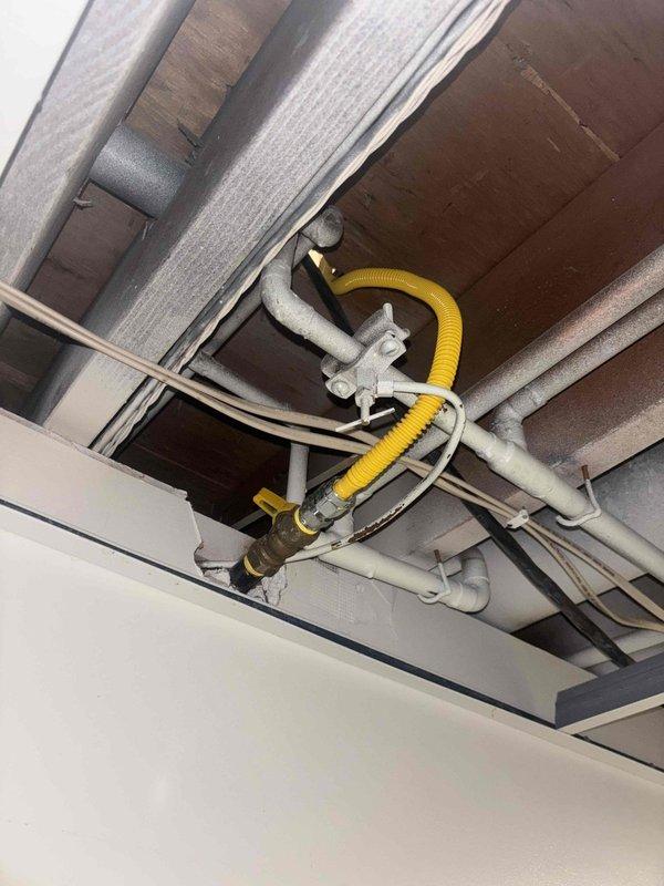 Installed new flexible gas line through ceiling and wall cavity to service kitchen appliance. Connected line to existing gas supply and secured properly to structural elements. Verified connections for proper seal and performed leak test to ensure safe operation.