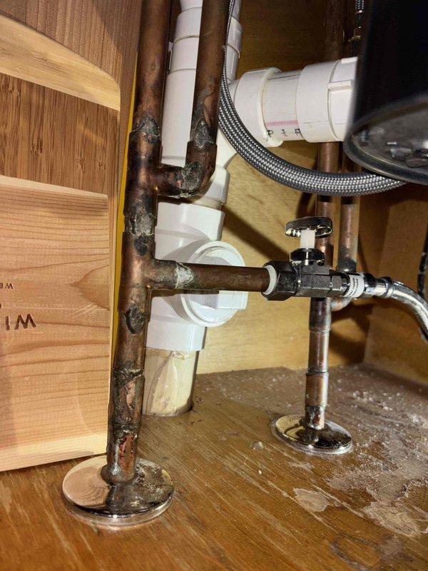 Inspected dishwasher water supply issue in 22-year-old home and identified significant corrosion on copper supply lines and water damage to cabinet floor beneath kitchen sink. Replaced corroded copper pipes, installed new shutoff valve with braided supply line, and verified proper water flow to dishwasher, restoring full functionality.