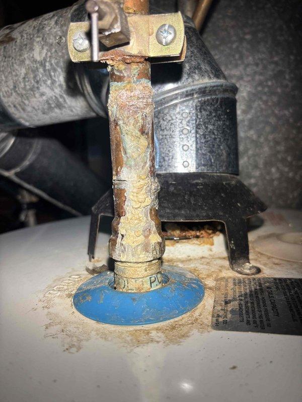 Responded to service call for non-functioning water heater with extinguished pilot light. Upon inspection, discovered severe corrosion on copper pipe connections with significant mineral buildup and water damage. Recommended replacement of aging water heater unit due to extensive deterioration of critical components and connection points.