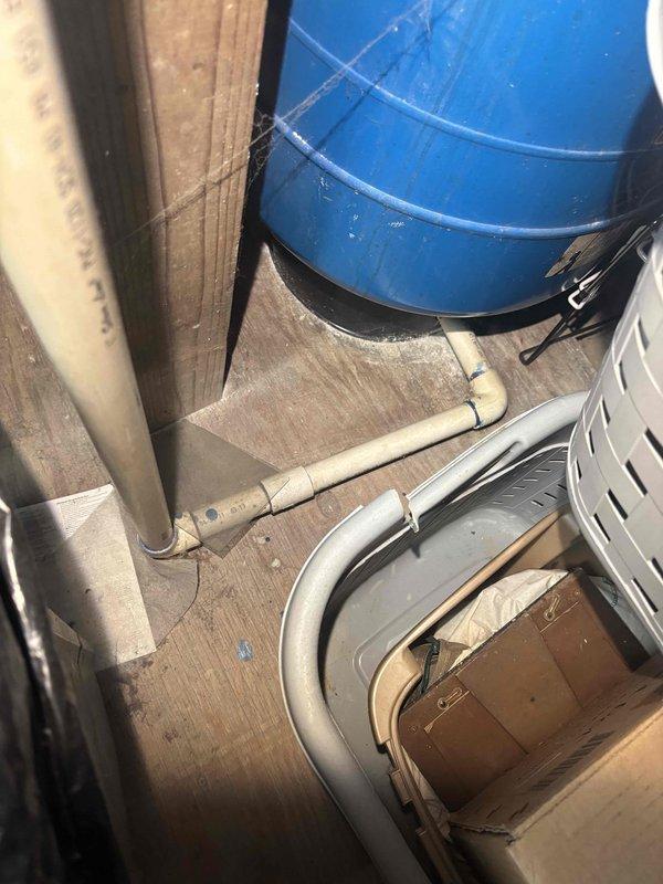 Diagnosed water heater with pilot light failure. Inspected blue cylindrical tank in basement utility area with connecting PVC plumbing. Serviced pilot assembly to restore proper ignition, successfully resolving the no hot water issue.