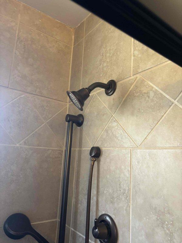 Responded to emergency service call for shower valve that would not shut off, requiring water to be turned off to the entire home. Replaced damaged cartridge and diverter assembly in the oil-rubbed bronze shower fixture system. Tested operation of both fixed showerhead and handheld wand components, confirming proper water flow control and complete shutoff functionality.