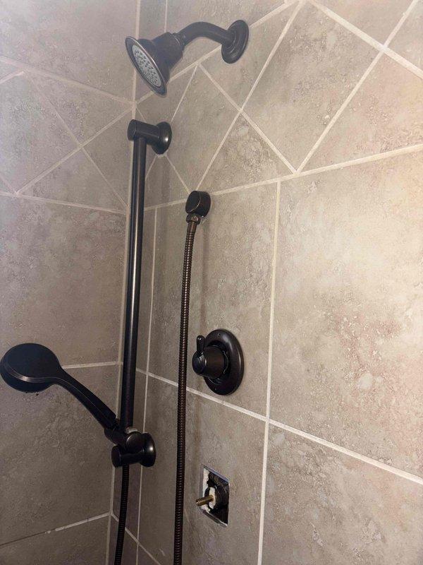 Responded to emergency service call for shower valve that would not shut off, requiring water to be turned off to the entire home. Replaced damaged cartridge and diverter assembly in the oil-rubbed bronze shower fixture system. Tested operation of both fixed showerhead and handheld wand components, confirming proper water flow control and complete shutoff functionality.