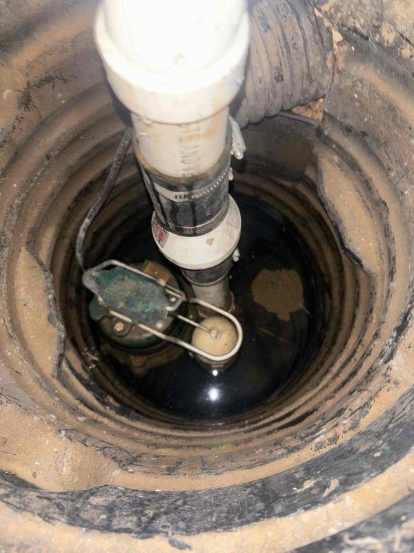 Performed diagnostic inspection of sump pump system in basement as requested by homeowner. Visual examination revealed a functional submersible pump with proper float switch mechanism and discharge pipe installation, though basin showed normal sediment buildup. Confirmed pump activates appropriately and is operating within normal parameters despite homeowner not hearing it during recent rainfall.
