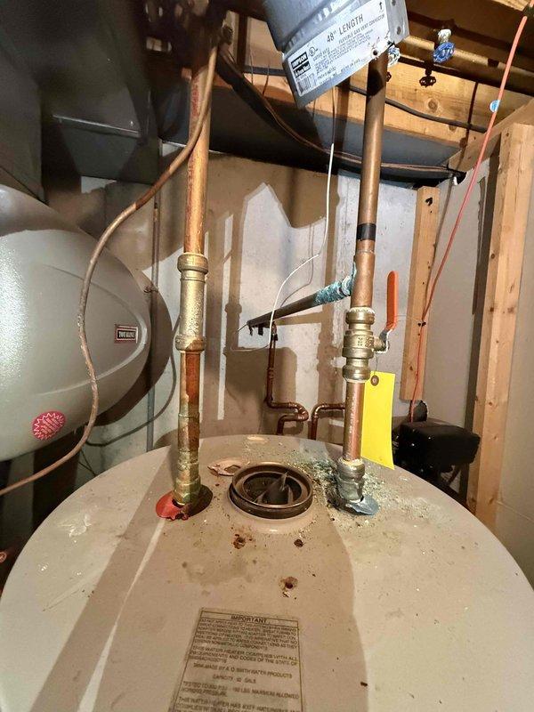 Installed new 50-gallon gas water heater with code-compliant copper piping and expansion tank in utility area. System includes proper ventilation with flexible metallic ducting and all necessary brass fittings. Installation complete and unit functioning as designed.