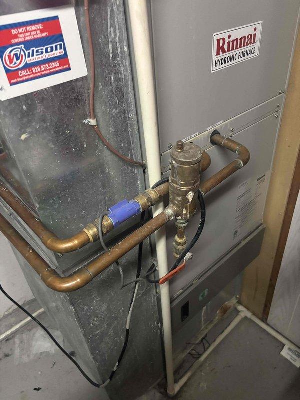 Inspected Rinnai hydronic furnace system with reported vibration issues. Determined unit was incorrectly installed with improper piping configuration and lacks manufacturer registration for warranty coverage. Documented installation deficiencies including substandard copper pipe connections and improper valve placement that are contributing to operational noise.