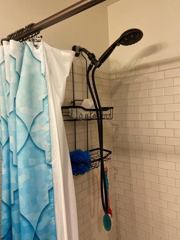 Conducted on-site evaluation for conversion of existing bathtub to walk-in shower. Inspected current bathroom configuration featuring white subway tile walls and standard bathtub with black fixtures. Documented measurements and existing plumbing connection points to prepare comprehensive estimate for complete tub-to-shower conversion.