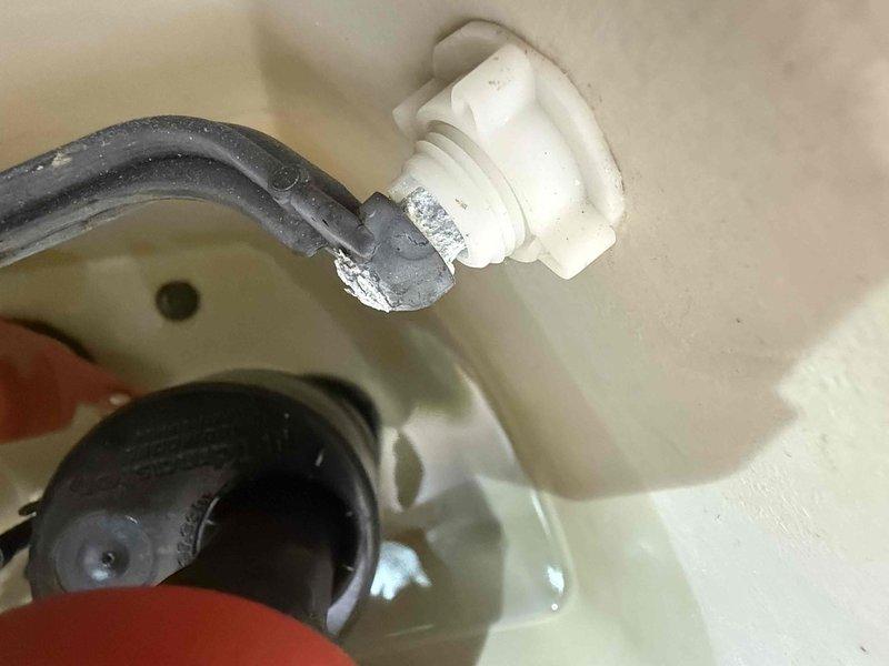 Performed water leak detection service, identifying mineral buildup and corrosion at the connection point between supply line and toilet tank fitting. Inspected basement plumbing system including water heater, expansion tank, and associated copper/PVC piping to locate source of leak.