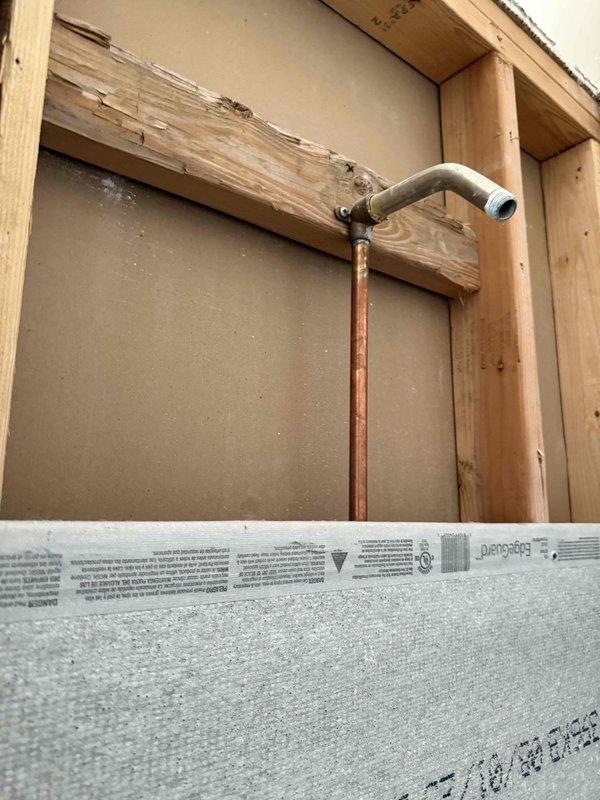 Reconfigured shower valve assembly and replaced damaged valve to accommodate new shower head installation. Assessed existing plumbing infrastructure which showed significant copper pipe oxidation and wooden framing damage. Additional visit scheduled to complete installation of new shower head components in the cement board-lined shower enclosure currently under renovation.