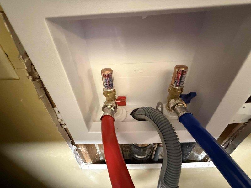 Successfully installed a new laundry box with dual water supply valves (hot and cold) and a drain connection. Completed all necessary connections including copper supply lines with brass shutoff valves and properly secured the gray corrugated drain hose within the recessed wall box. Verified proper function of all components before completing the installation.