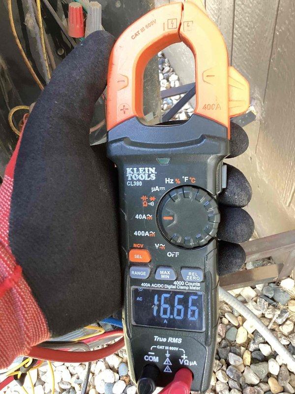 Performed scheduled maintenance on a side-mounted cooling unit. Conducted electrical diagnostic testing using a Klein Tools CL390 clamp meter, measuring amperage draw at 1.666A. Inspected interior electrical components including capacitors, circuit board, and terminal connections, noting some dust accumulation and cobwebs on the wiring harness. All systems verified operational with readings within manufacturer specifications.