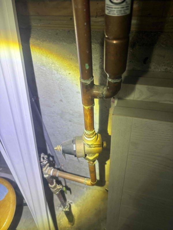 Performed comprehensive whole home plumbing inspection with special focus on the main water supply system. Inspected brass pressure regulator valve (IPSO brand) and associated copper piping, noting some natural tarnishing and aging of components but confirming all connections remain properly soldered and functional. No immediate issues requiring repair were identified during the inspection.