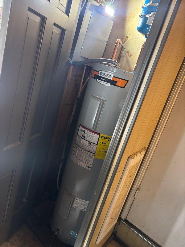 Successfully installed a 40-gallon tall State electric water heater with copper piping connections and expansion tank in a confined utility space. System features include proper pressure regulation components and all required plumbing connections. Installation comes with 1-year labor warranty and 6-year tank and parts warranty, pending installation of a dedicated electrical line by a licensed electrician.