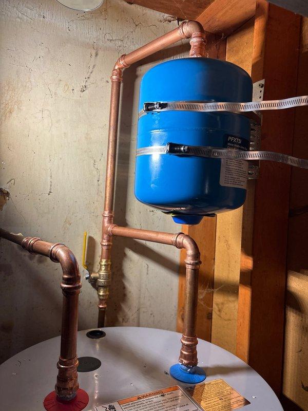 Successfully installed a 40-gallon tall State electric water heater with copper piping connections and expansion tank in a confined utility space. System features include proper pressure regulation components and all required plumbing connections. Installation comes with 1-year labor warranty and 6-year tank and parts warranty, pending installation of a dedicated electrical line by a licensed electrician.