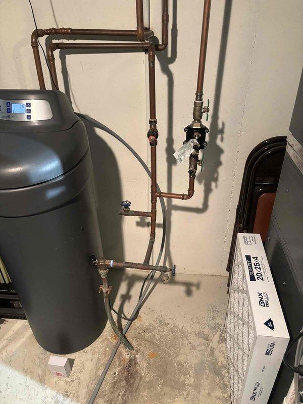 Completed on-site assessment for 50-gallon water heater replacement in basement location. Evaluated existing plumbing configuration including water softener system, copper supply lines, pressure regulation valve assembly with gauge, and connection points to determine installation requirements for customer-preferred AO Smith unit.