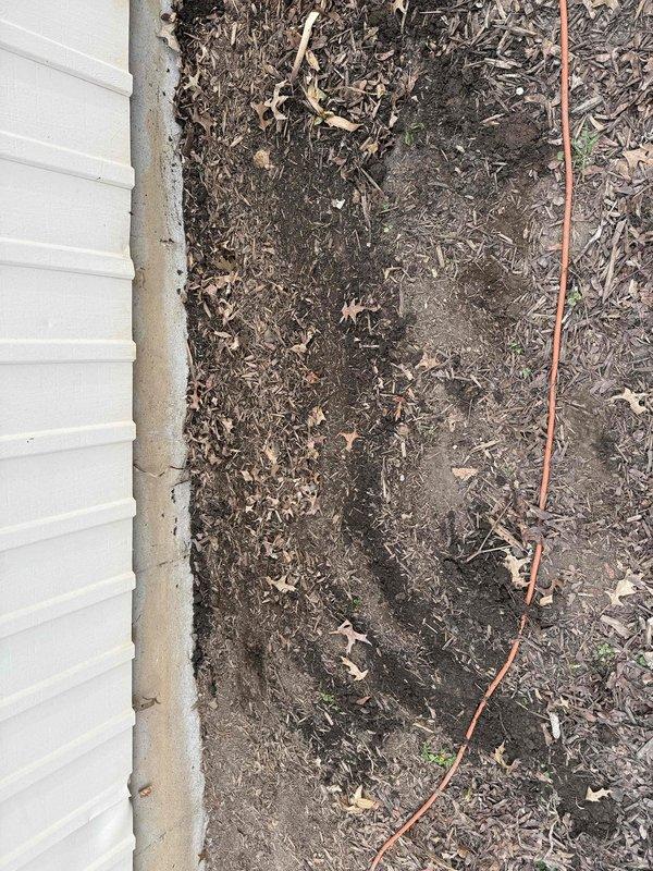 # Plumbing Service Report

Excavated and exposed underground sump pump discharge line buried approximately 1-2 feet below grade near building foundation. Removed damaged section of discharge piping and installed new pipe segment with flexible rubber couplings and stainless steel hose clamps to ensure secure, leak-free connections. Backfilled excavation area with soil, restored grade level, and performed operational testing to verify proper drainage flow through the repaired discharge line.