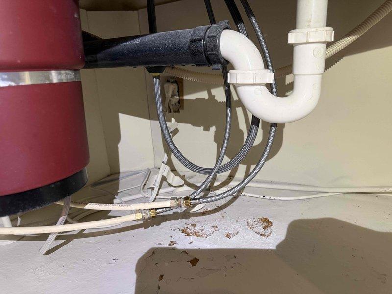 # Service Report: Kitchen Faucet Installation

Successfully installed customer-supplied kitchen faucet with integrated sprayer on double-basin composite sink with granite countertop. Installation included mounting the rose gold/copper-finish faucet assembly, connecting hot and cold water supply lines with braided stainless steel flex hoses, securing all mounting hardware through countertop, and verifying proper operation of both standard flow and pull-out sprayer functions. All connections tested and confirmed leak-free with no issues detected in the P-trap drainage system or under-sink plumbing configuration.