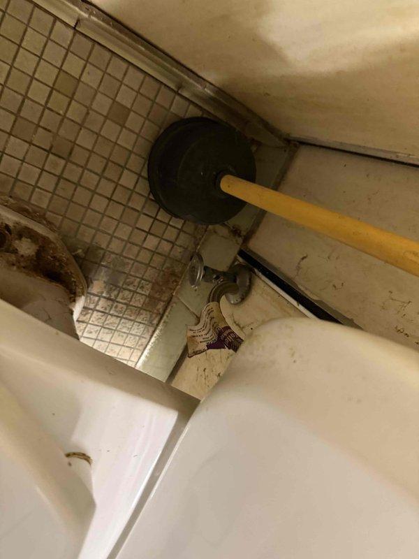 Completed estimate for commercial restroom with two toilet fixtures requiring repair. First toilet identified as loose at floor mounting with evidence of water leakage at base, requiring reset with new wax ring and flange bolts. Second toilet diagnosed with inadequate flush performance due to partial blockage or flush valve malfunction, requiring further evaluation of flush mechanism and trapway clearance. Documented existing conditions of both squat-style toilet fixture and standard toilet installation for repair specifications.