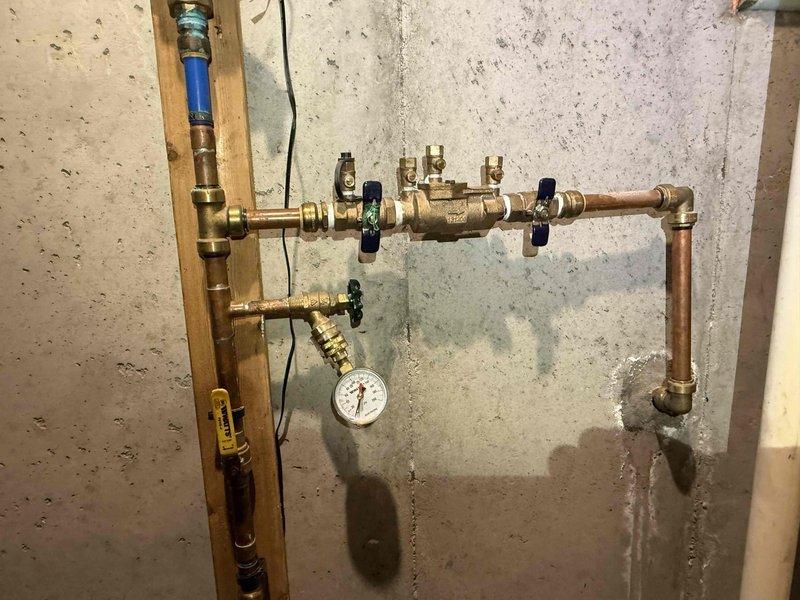 Installed a new 3/4" pressure reducing valve (PRV) on the main water line in the basement utility area. Replaced all existing push-fit connections with permanent copper fittings, utilizing 3/4" copper pipe and brass fittings throughout to ensure a durable, code-compliant installation. The upgraded system includes a brass manifold with multiple shut-off valves for zone control and an integrated pressure gauge for monitoring water pressure, eliminating the risk of failure associated with the previous push-fit connections.