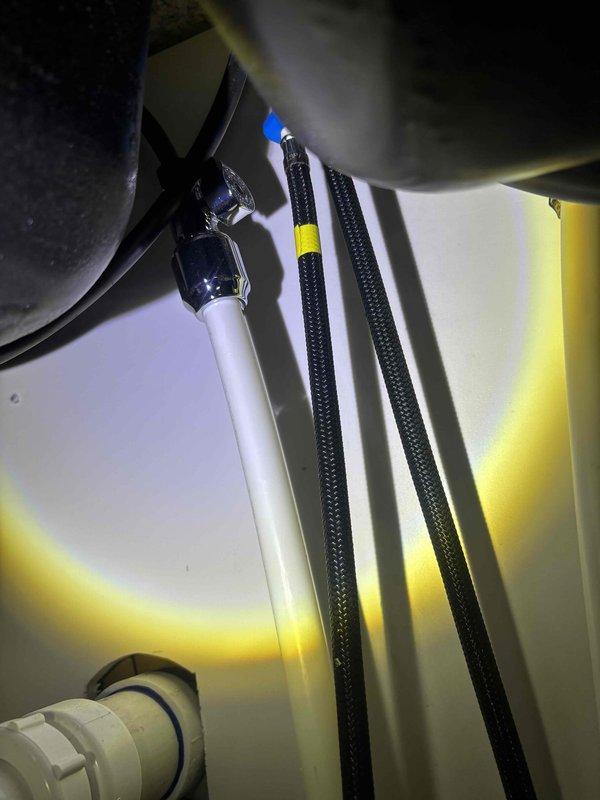 Completed comprehensive plumbing inspection of residential property. Examined utility room plumbing connections including PVC supply lines, chrome fittings, and braided supply hoses, confirming proper installation and secure connections. Inspected bathroom shower system including wall-mounted chrome showerhead fixture and water pressure performance, verifying adequate flow and spray pattern functionality with no visible leaks or drainage issues detected.